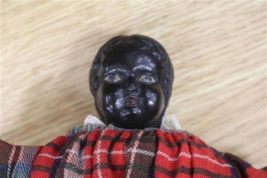 A Victorian doll wearing a tartan dress